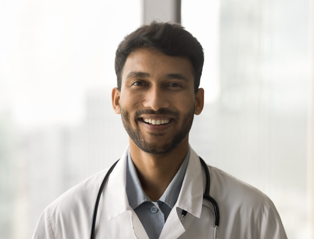 Positive,Attractive,Indian,Doctor,Man,In,White,Uniform,Coat,And
